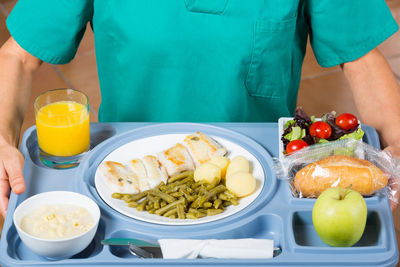 Midsection of doctor holding food in tray