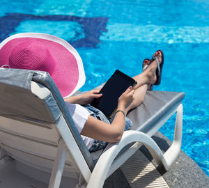 Man sitting on chair at swimming pool