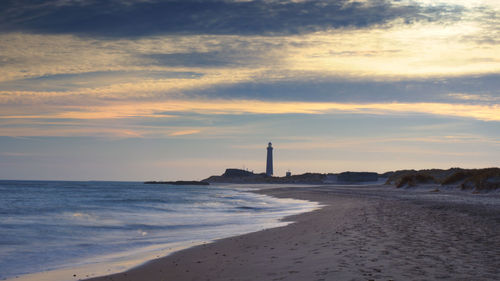 View of lighthouse at beach during sunset