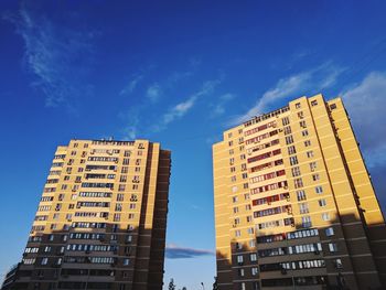 Low angle view of modern buildings against blue sky