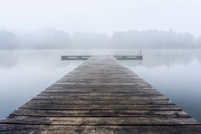 Pier over lake against sky