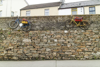 Bicycle parked against brick wall of building