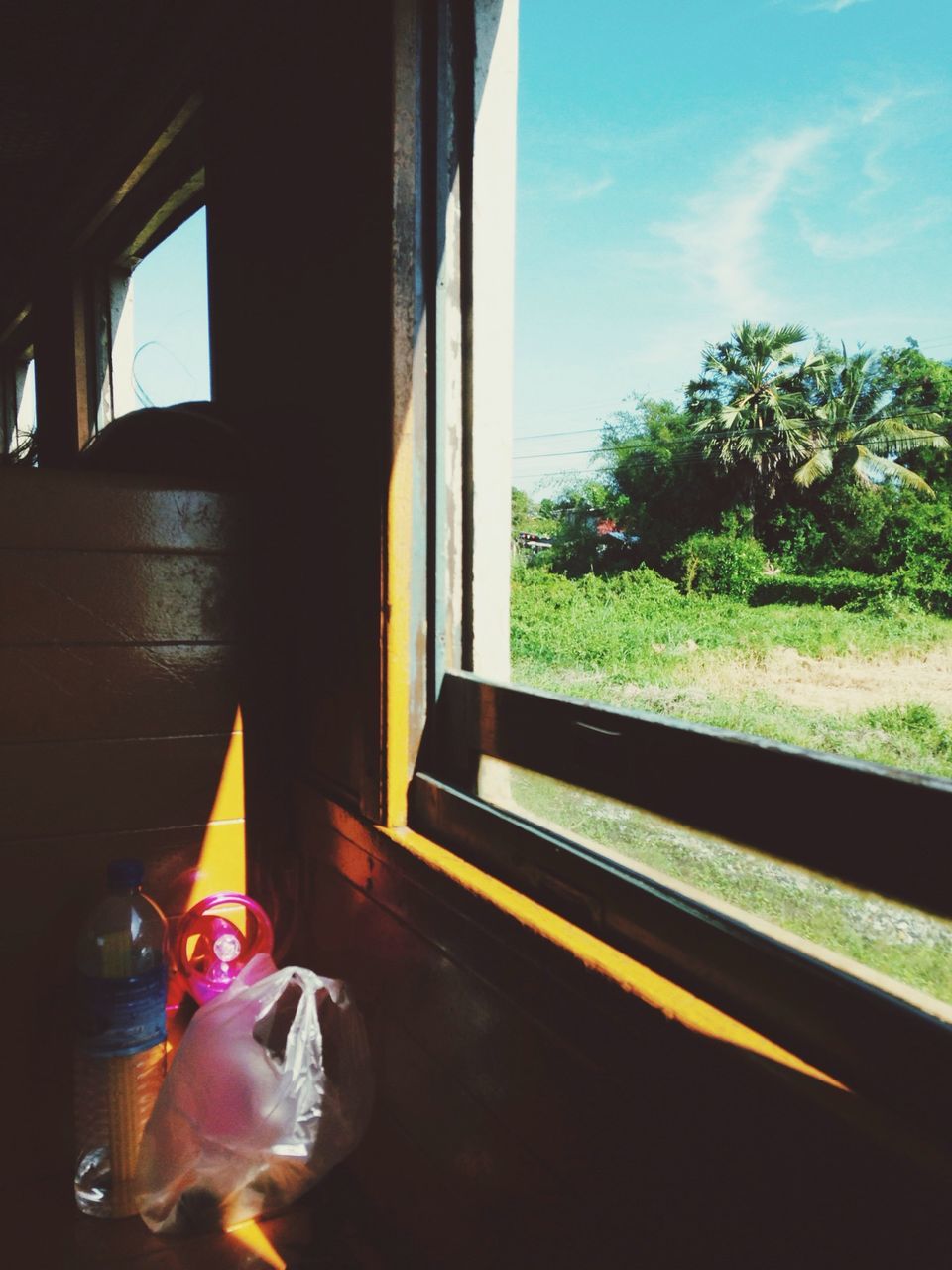 glass - material, window, sunlight, transparent, sky, transportation, reflection, indoors, land vehicle, car, sunbeam, mode of transport, tree, lens flare, sun, sunset, day, no people, built structure, shadow