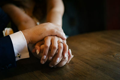 Close-up of couple hands on table