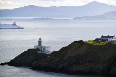 Lighthouse by sea against sky