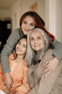 Portrait of happy multi-generation family embracing together at home