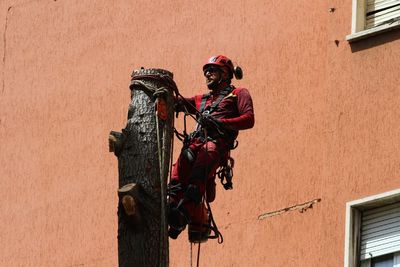 Low angle view of people on wall of building