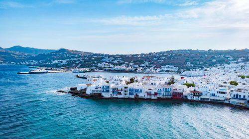 High angle view of sea by cityscape against sky