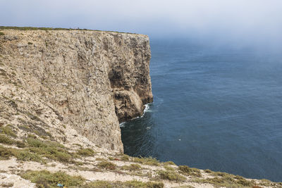 Rock formations by sea against sky