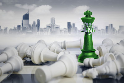 Digital composite image of chess pieces with flag against buildings in city