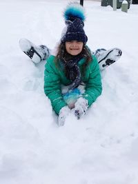 Portrait of girl playing with snow on field