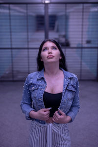 Fashionable young woman standing in illuminated built structure