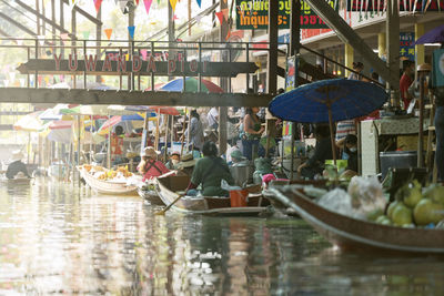 People in boats shopping at farmer's market along canal