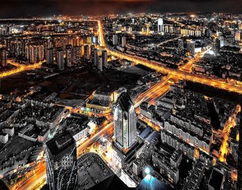 High angle view of city lit up at night