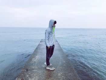 Man standing in sea against sky