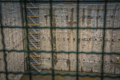 Full frame shot of metal fence against wall