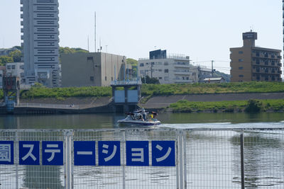 Boats moored on river in city against clear sky