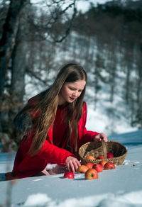 Girl picking apples on snow covered land