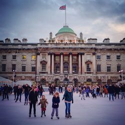 Crowd on ice rink against somerset house in city