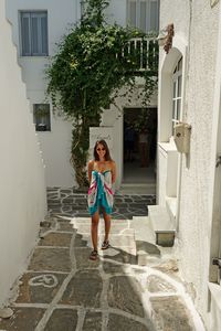 Full length of woman standing on staircase outside building