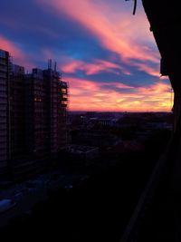 Silhouette cityscape against sky during sunset