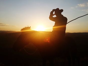 Cowboy on horse at sunset