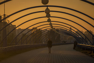 Rear view of people walking in tunnel