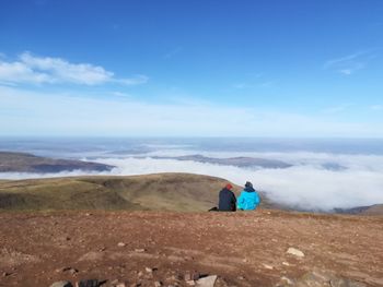 A couple sitting together enjoying the view at the summit of pen y fan