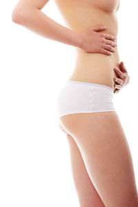 Midsection of woman standing against white background