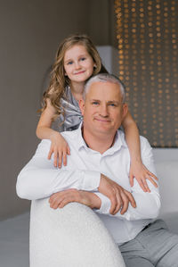 Portrait of young woman sitting on bed at home