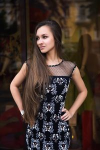 Young woman in dress standing outdoors