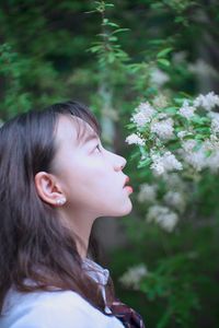 Close-up of woman smelling flowering plants