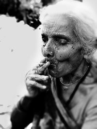 Senior woman smoking beedi