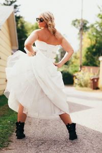Rear view of playful bride in wedding dress standing on road