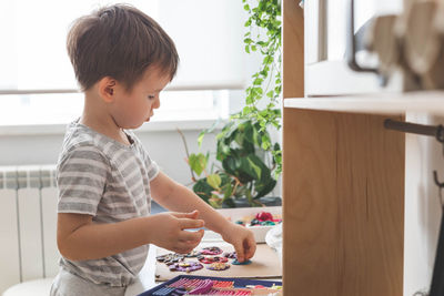 Side view of boy looking through window