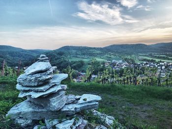 Stack of rocks on landscape against sky