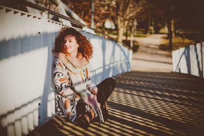 Woman sitting on footbridge