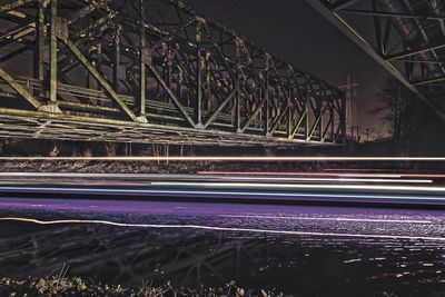 Light trails on bridge in city at night