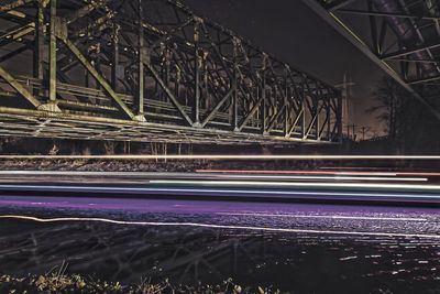 Light trails on bridge in city at night