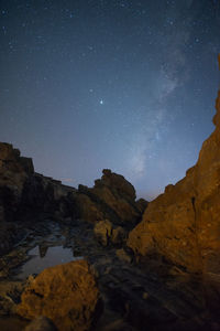 Scenic view of rock formations against sky at night