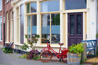 A red bicycle in front of a shop window of a historic building