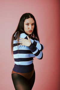 Portrait of woman standing against wall