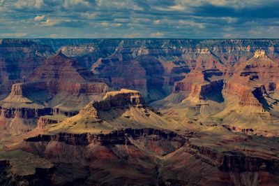 Aerial view of rock formations against cloudy sky