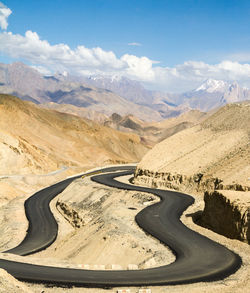 Scenic view of road by mountains against sky