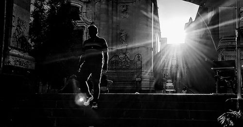 Low angle view of people on staircase amidst buildings in city