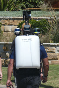 Rear view of man standing at yard