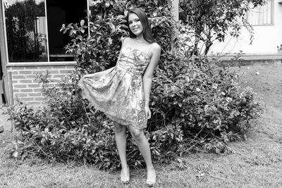 Portrait of smiling young woman against plants