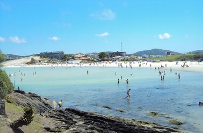 People on beach against blue sky