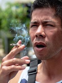 Close-up portrait of man smoking cigarette