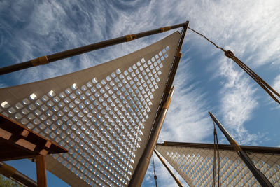 Low angle view of modern building against cloudy sky